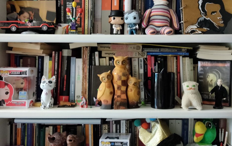 Repisa con libros en desorden y figuras diversas